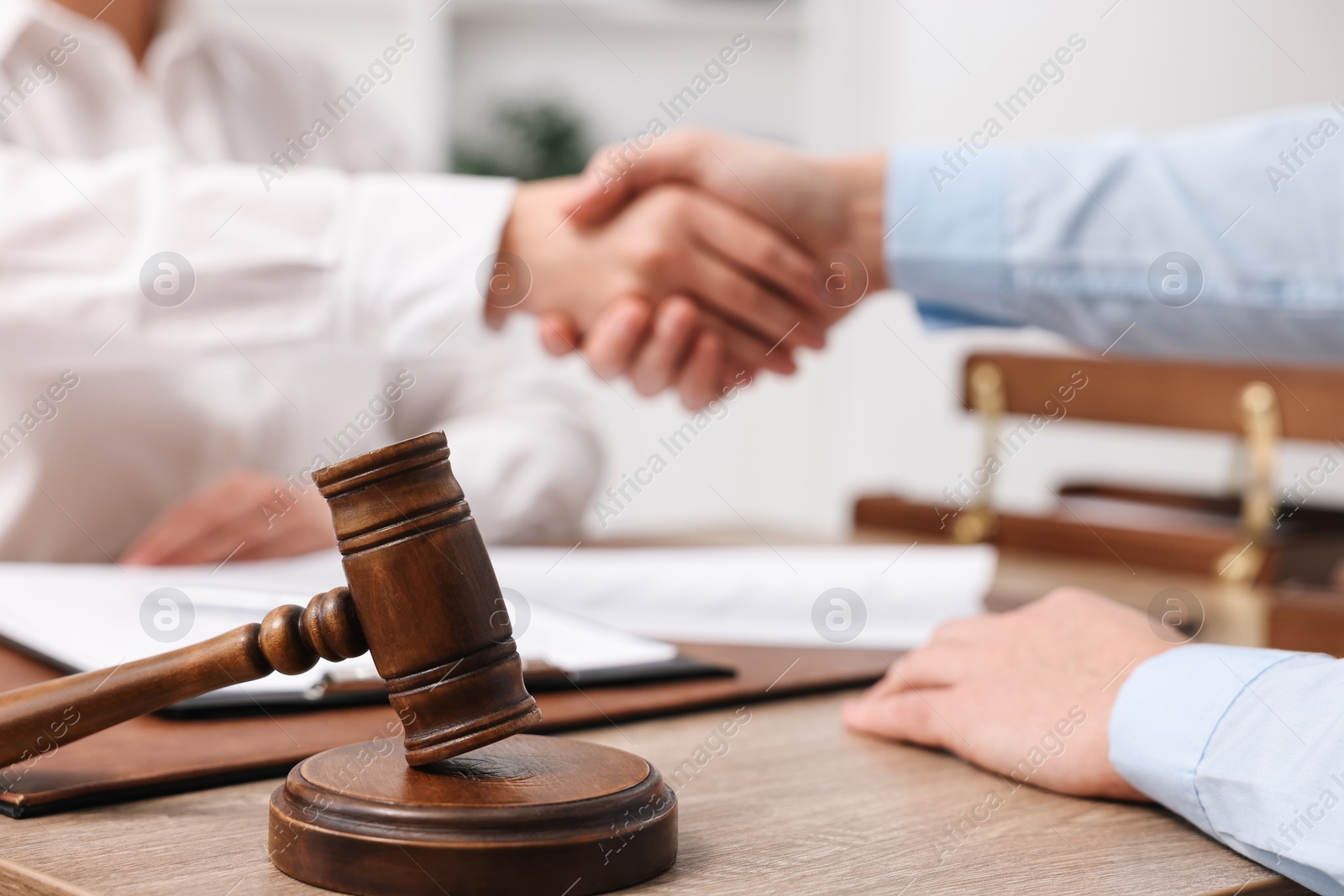 Photo of Lawyers shaking hands at table in office, closeup