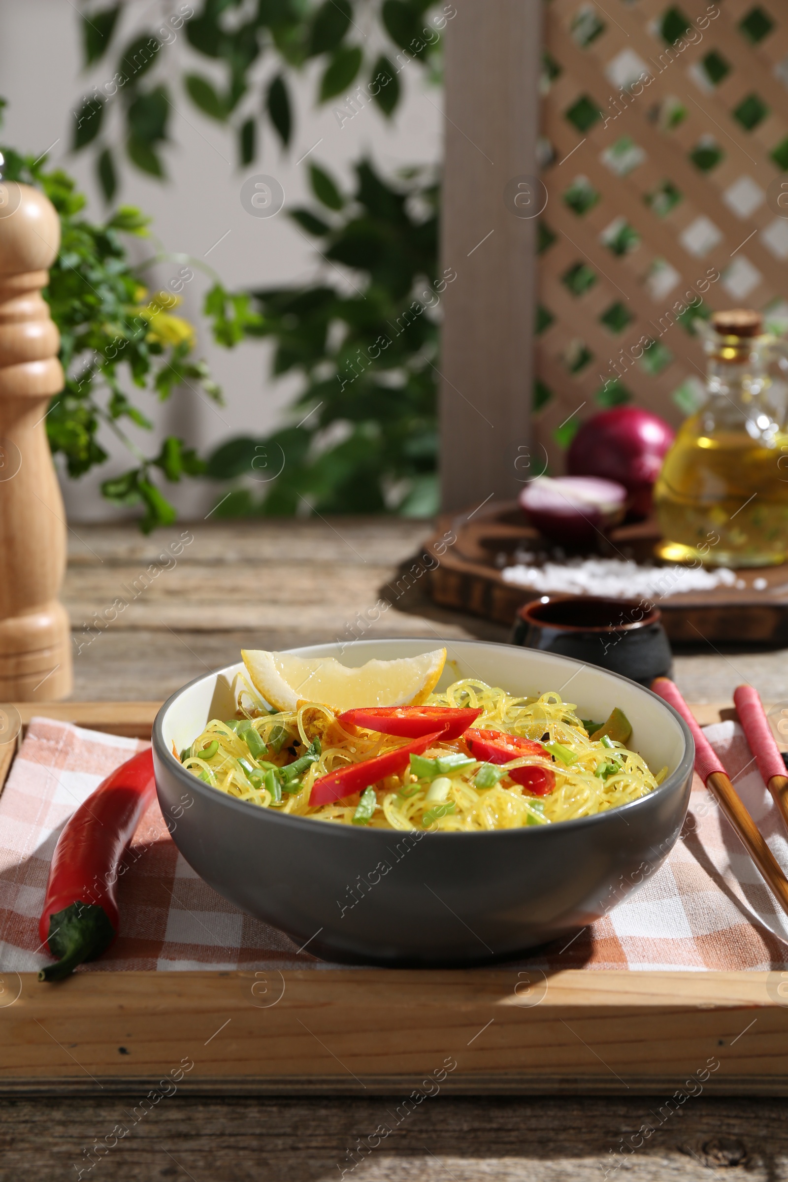 Photo of Stir-fry. Tasty noodles with vegetables and meat in bowl served on wooden table