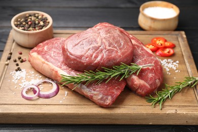 Photo of Pieces of raw beef meat and spices on table, closeup