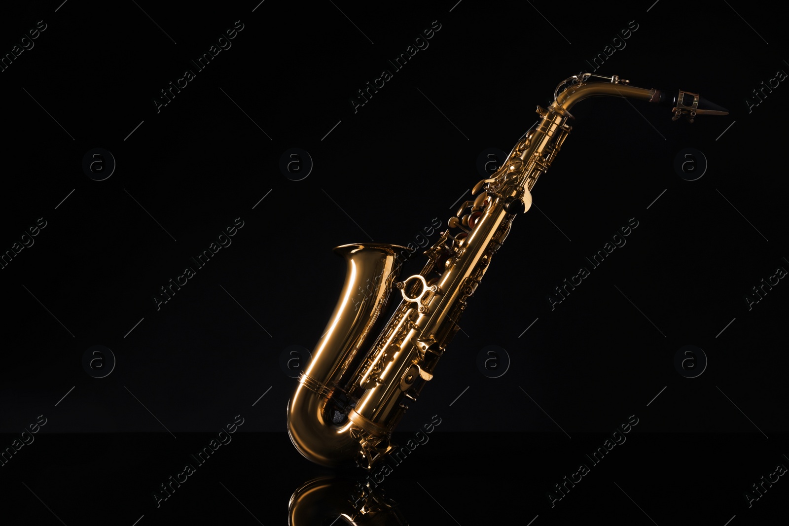 Photo of Beautiful saxophone on black background. Musical instrument