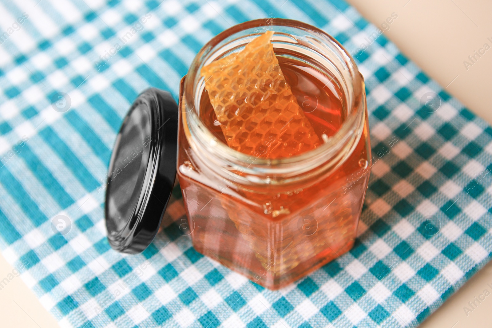 Photo of Jar with honey and combs on light table