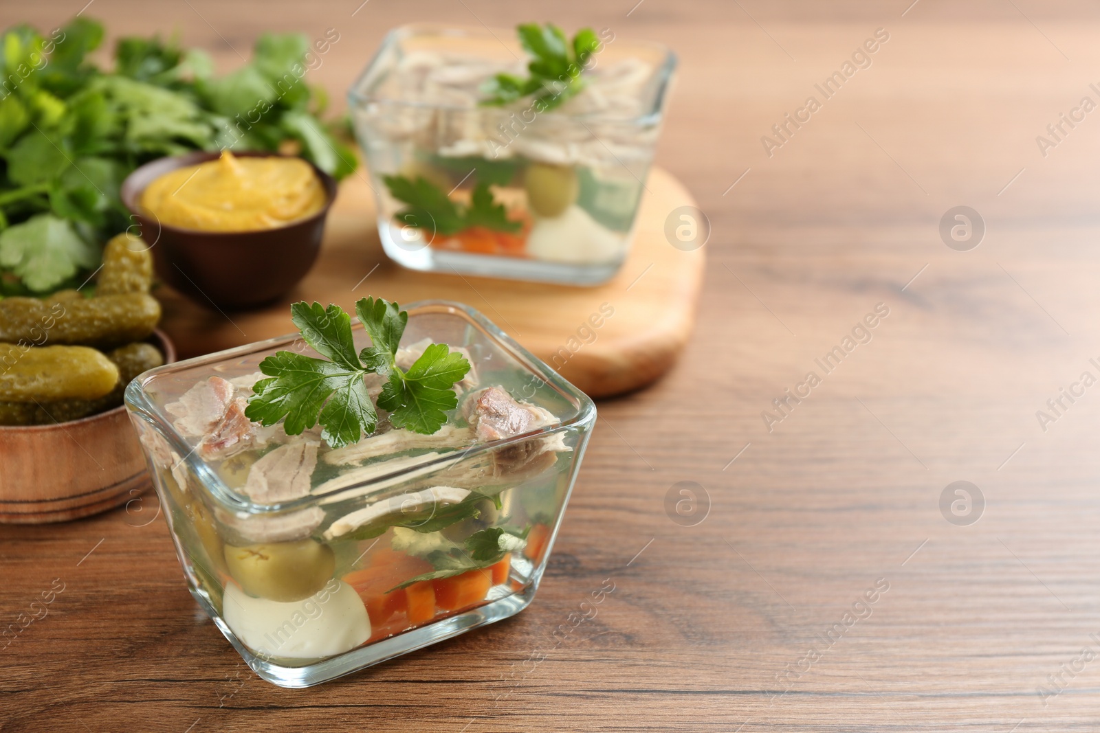 Photo of Delicious aspic with meat served on wooden table. Space for text