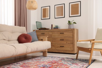 Photo of Beautiful rug, sofa, armchair and chest of drawers indoors