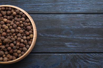 Photo of Peppercorns on dark blue wooden table, top view. Space for text