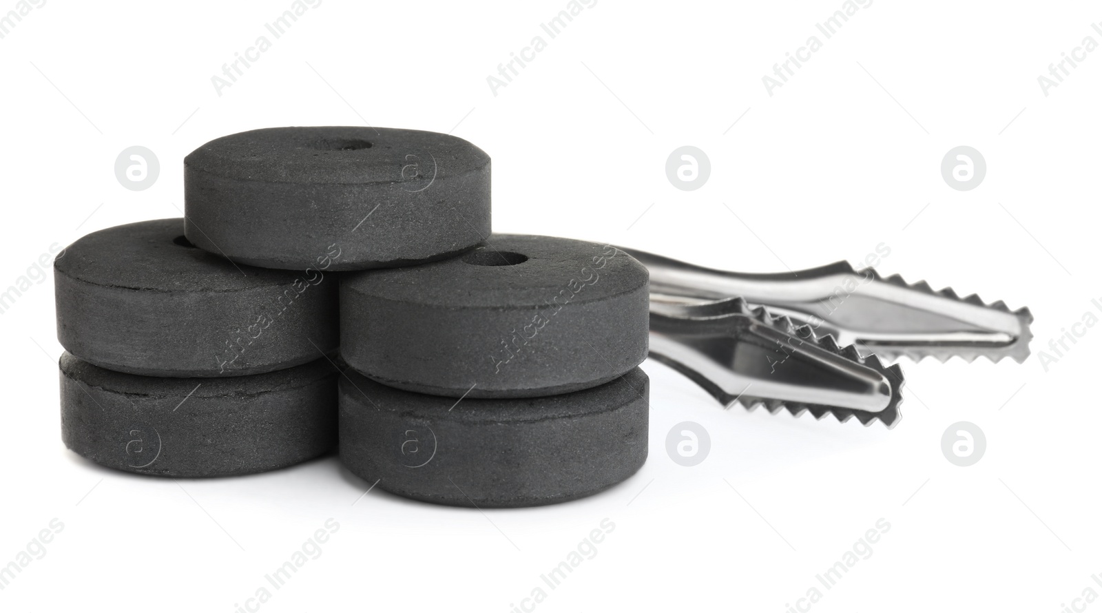 Photo of Charcoal rings for hookah and tongs on white background