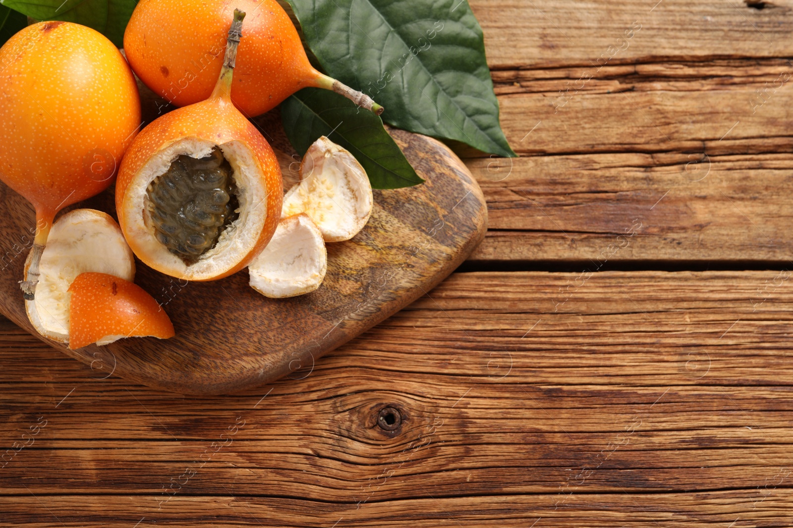 Photo of Delicious ripe granadillas on wooden table, top view. Space for text