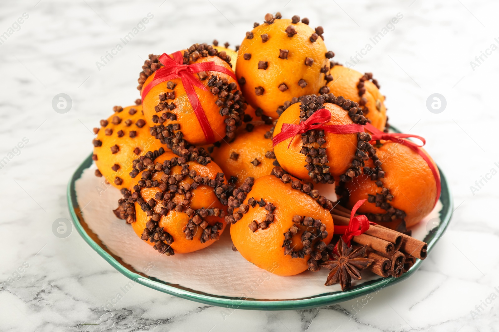 Photo of Pomander balls made of fresh tangerines and cloves white marble table