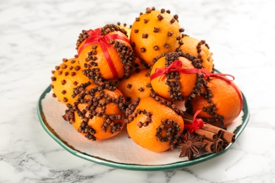 Pomander balls made of fresh tangerines and cloves white marble table