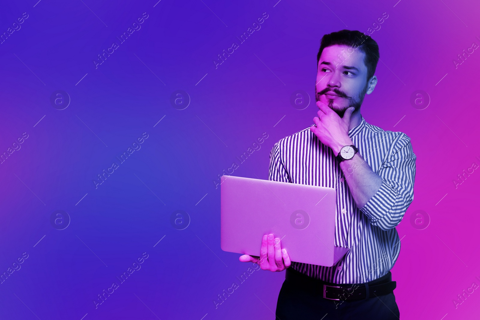 Image of Handsome man with laptop in neon lights, space for text