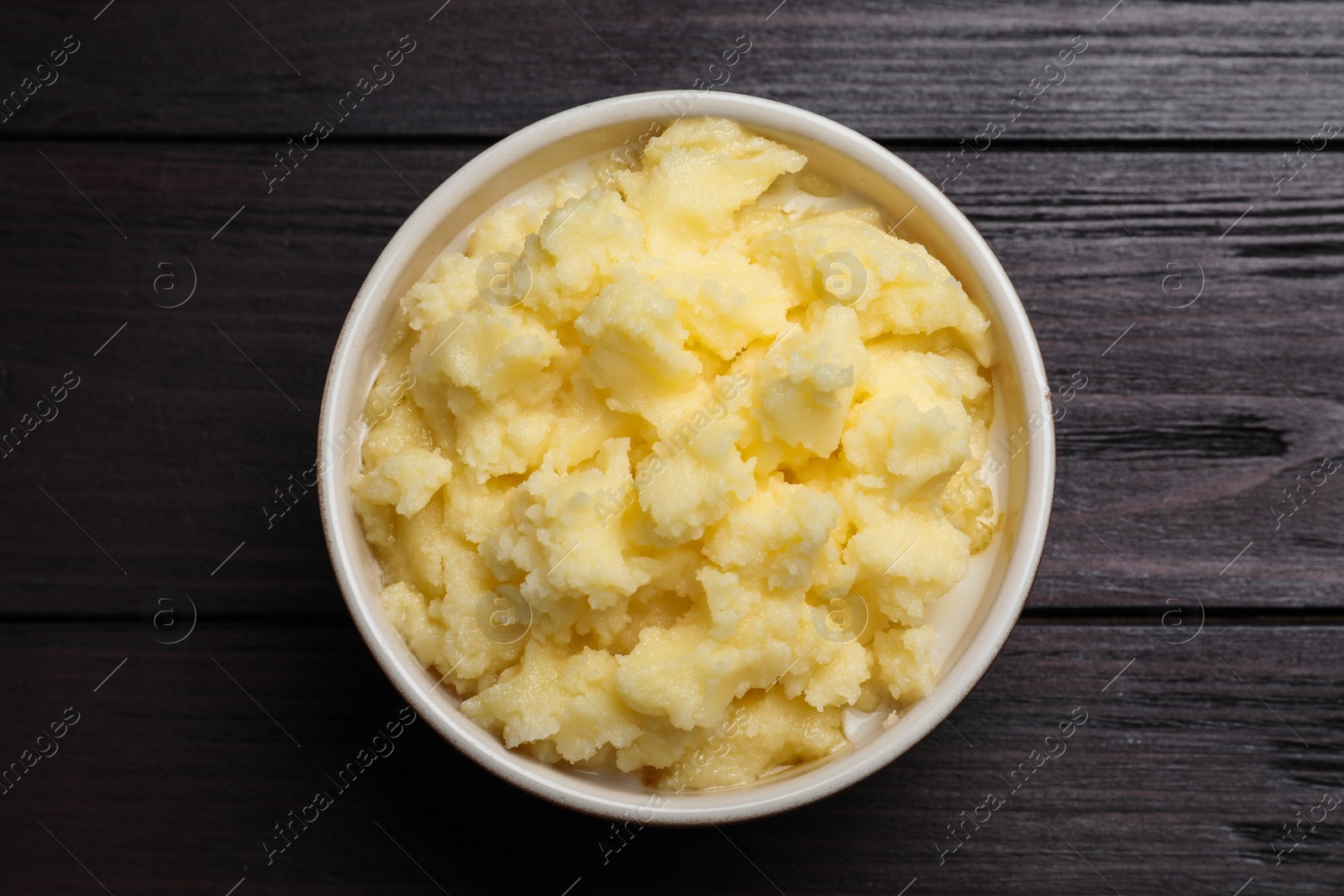 Photo of Bowl of Ghee butter on wooden table, top view