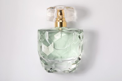 Photo of Luxury women's perfume in bottle on white background, top view