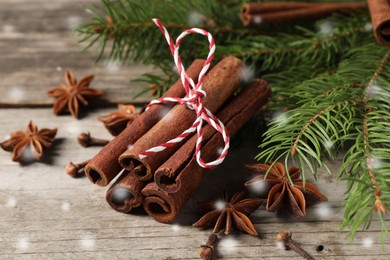 Image of Different spices and fir tree branches on wooden table, closeup. Cinnamon, anise, cloves