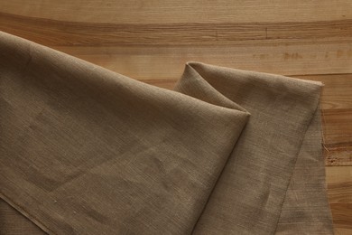 Burlap fabric on wooden table, top view