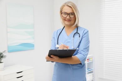 Photo of Doctor wearing uniform with clipboard in clinic
