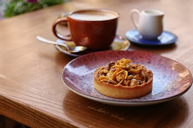 Photo of Plate with delicious cake on wooden table