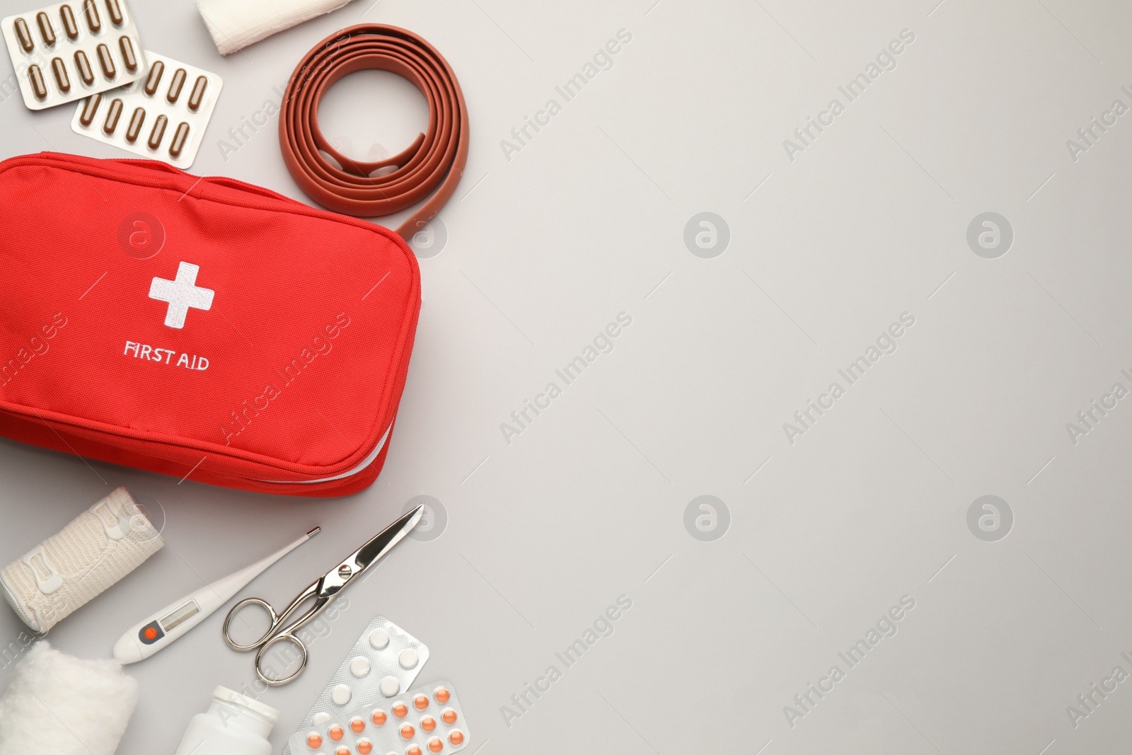 Photo of Flat lay composition with first aid kit on light grey background, space for text