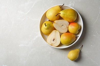 Photo of Plate with pears on grey background, top view. Space for text