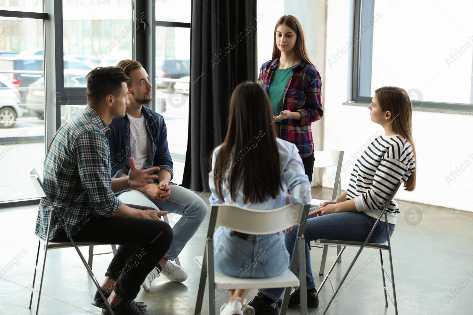 Photo of Psychotherapist working with patients in group therapy session indoors