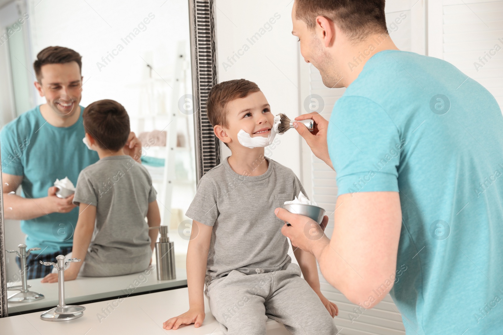 Photo of Dad applying shaving foam onto son's face in bathroom