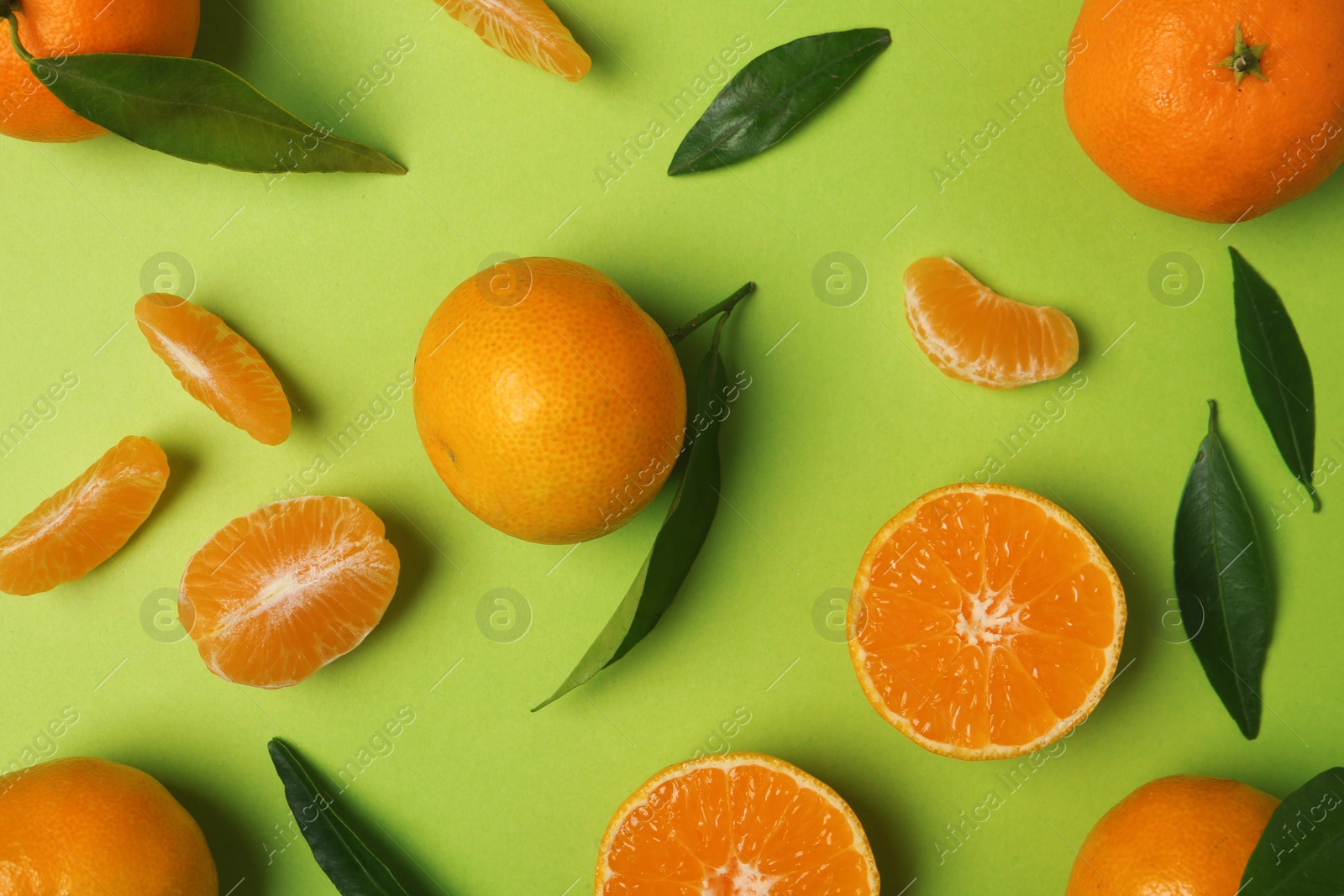 Photo of Composition with tangerines and leaves on color background, flat lay