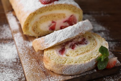 Photo of Pieces of delicious cake roll with strawberries and cream on table, closeup