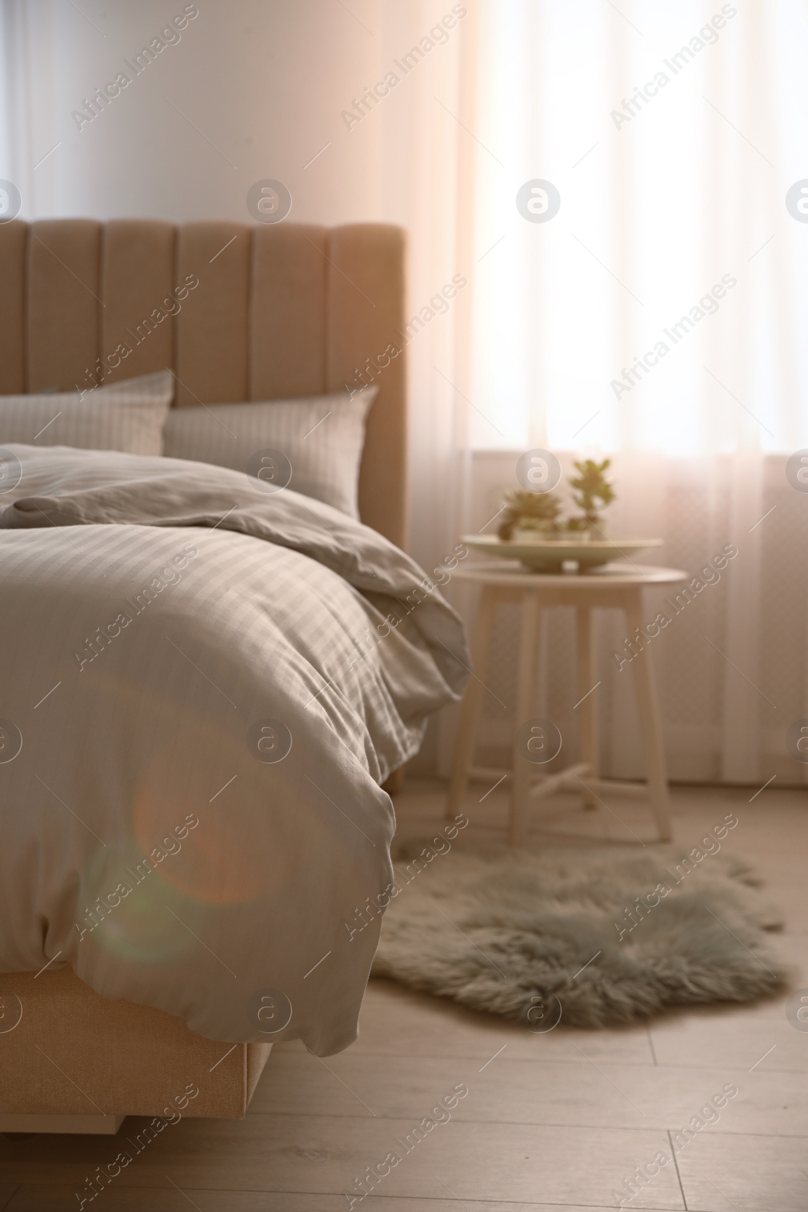 Photo of Comfortable bed with soft blanket near window indoors