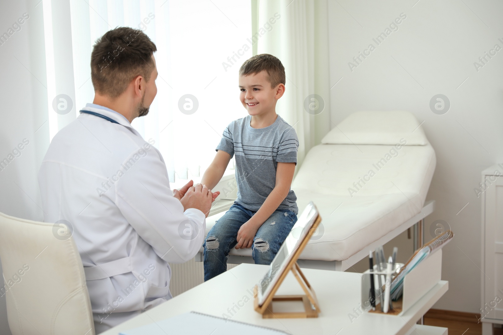 Photo of Children's doctor working with little patient in clinic