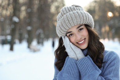 Portrait of smiling woman in snowy park. Space for text