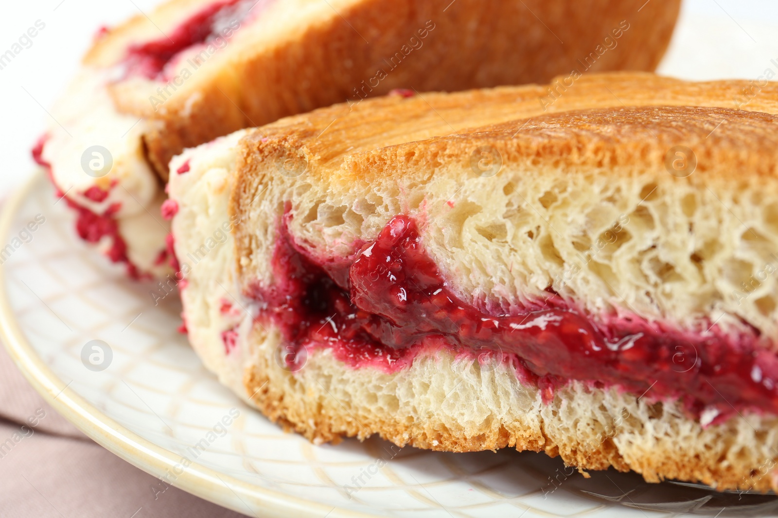 Photo of Round croissant with jam on table, closeup. Tasty puff pastry