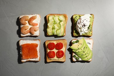 Photo of Different delicious toasts on light grey table, flat lay