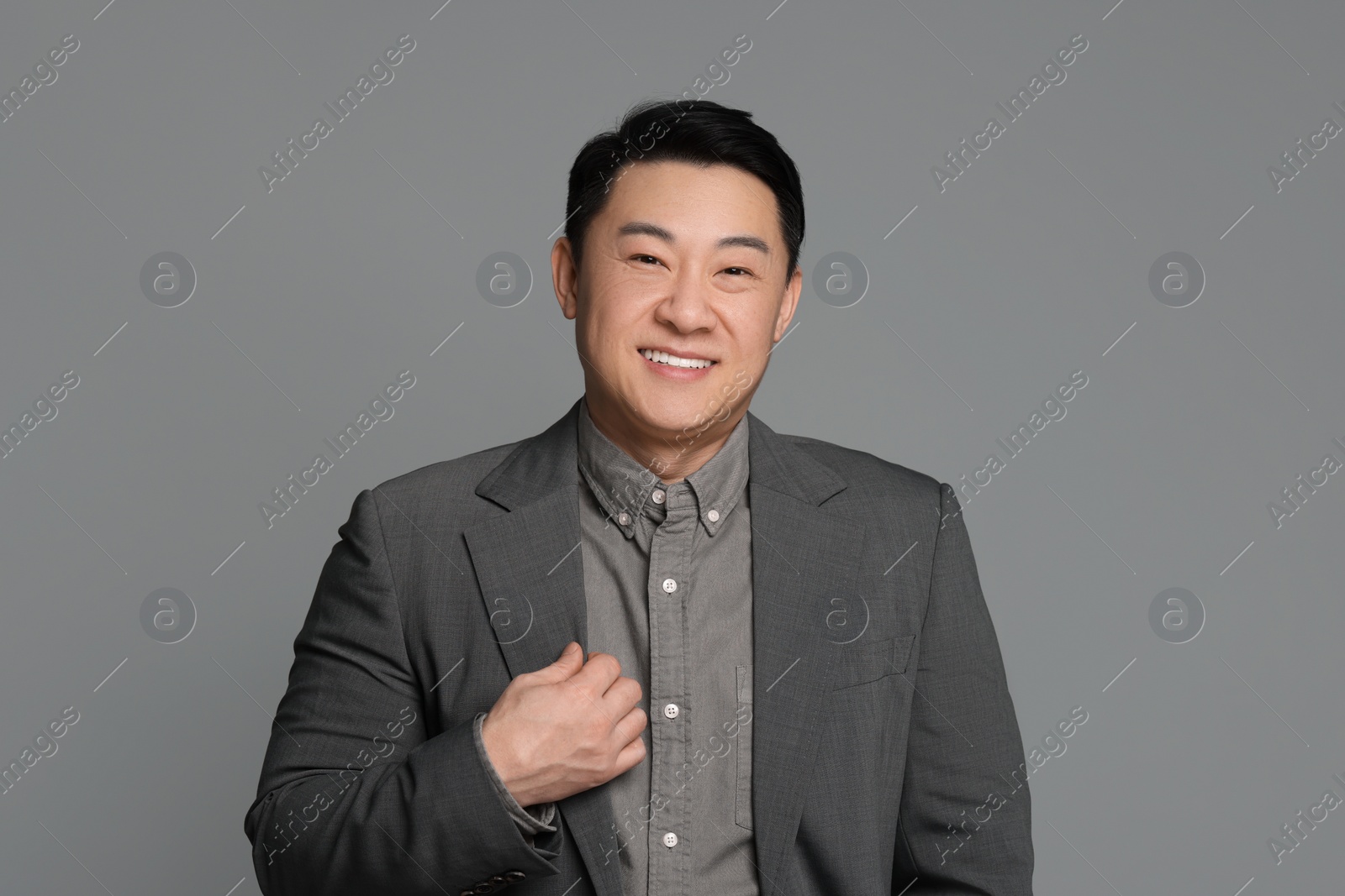 Photo of Portrait of happy businessman on grey background