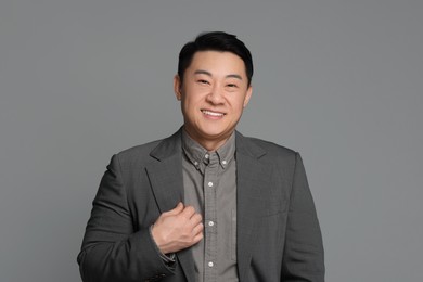 Portrait of happy businessman on grey background