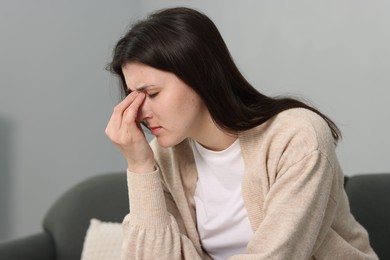 Overwhelmed woman suffering from headache at home