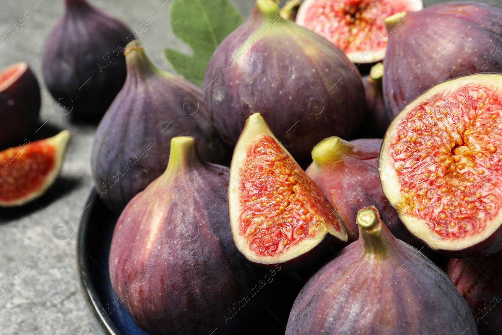 Photo of Whole and cut ripe figs on table, closeup