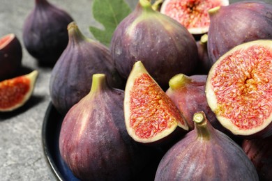 Whole and cut ripe figs on table, closeup