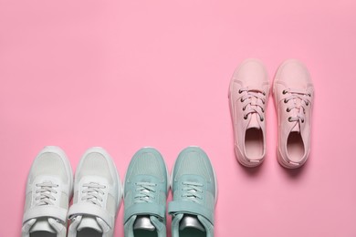 Different stylish sports shoes on pink background, flat lay. Space for text