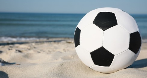 Photo of Soccer ball on beach, space for text. Football equipment