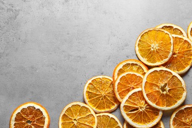 Photo of Dry orange slices on light grey table, flat lay. Space for text