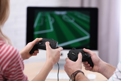 Photo of Young couple playing video game at home, closeup