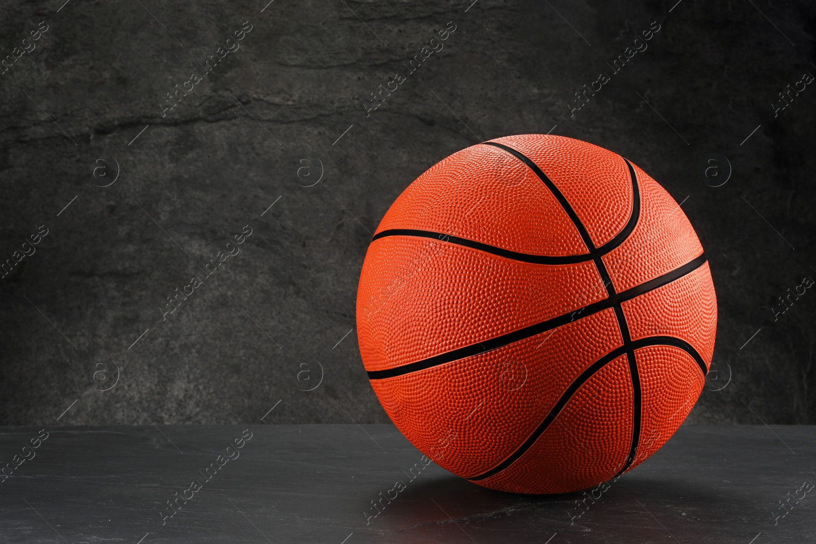 Photo of Basketball ball on dark gray background, space for text