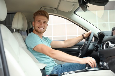 Photo of Happy young man driving his luxury car