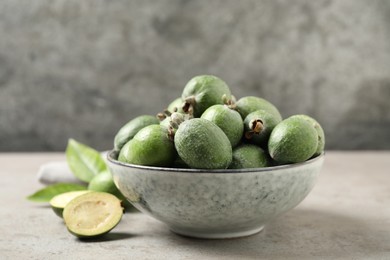 Fresh green feijoa fruits on light grey table, closeup