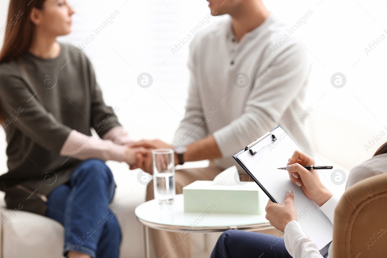 Photo of Professional psychologist working with couple in office