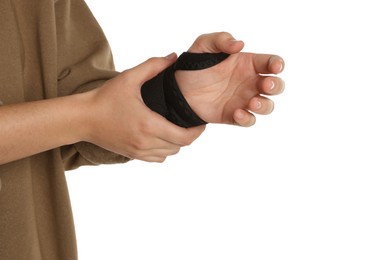 Woman wrapping hand in medical bandage on white background, closeup