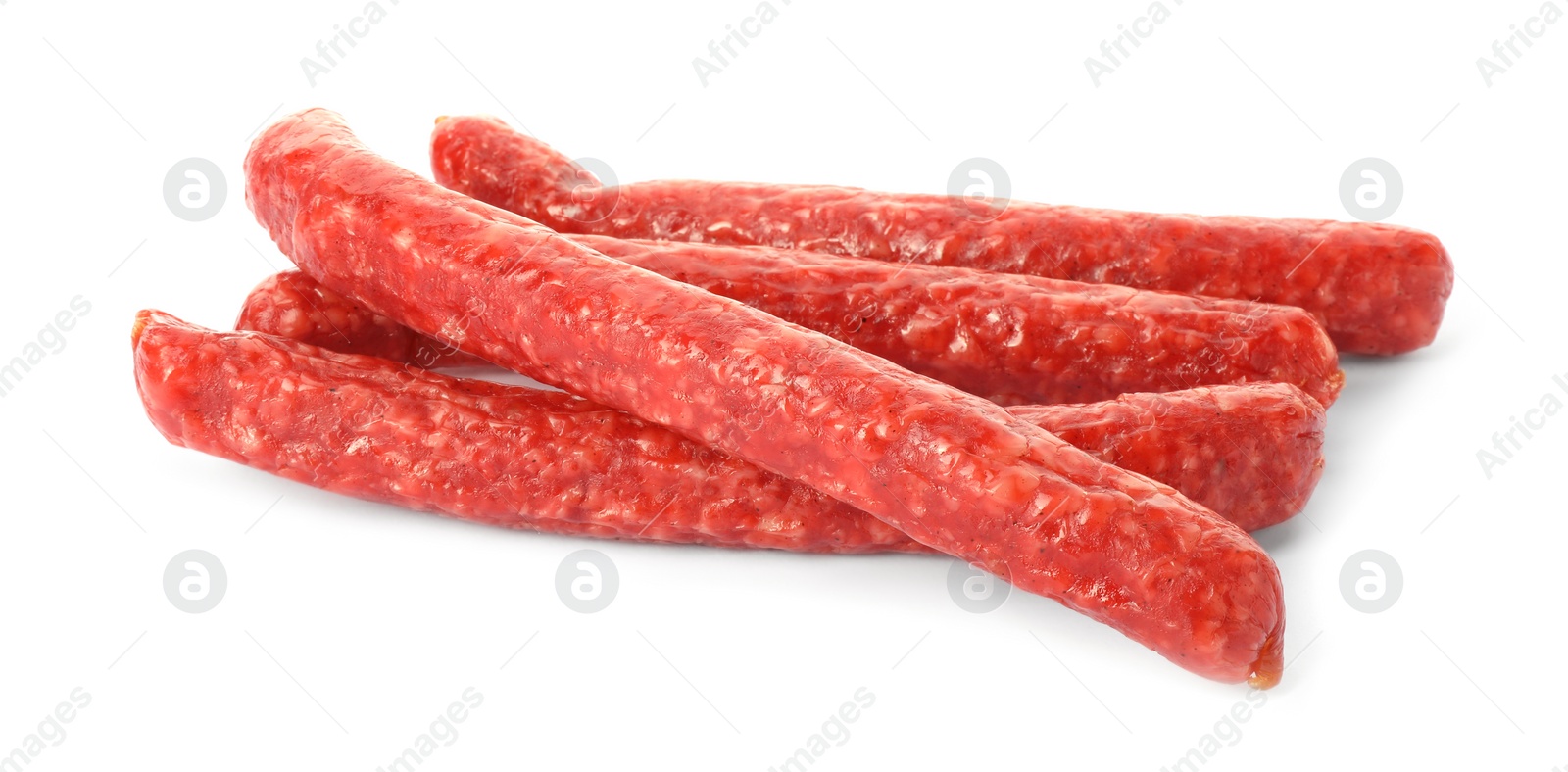 Photo of Many thin dry smoked sausages isolated on white