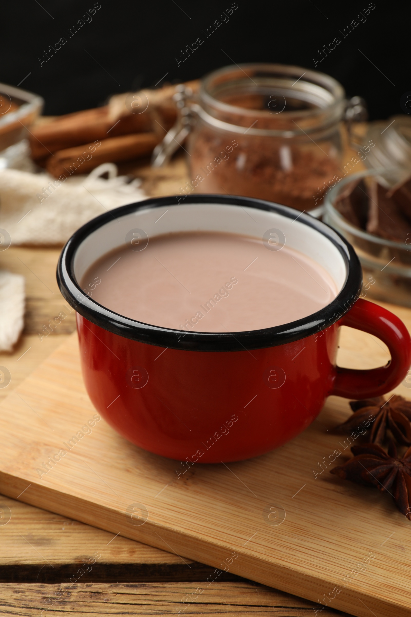 Photo of Tasty hot chocolate in cup on wooden table, closeup