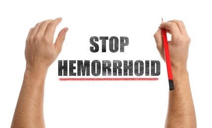 Image of Man writing phrase Stop Hemorrhoid on white background, closeup