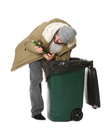 Poor homeless man digging in trash bin isolated on white