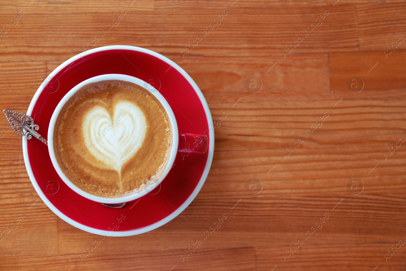 Photo of Cup of fresh aromatic coffee on wooden table, top view