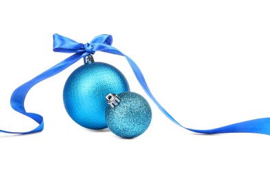 Photo of Beautiful Christmas balls and blue ribbon isolated on white